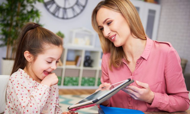 Copil care învață cu ajutorul unei tablete în timpul unei sesiuni educaționale